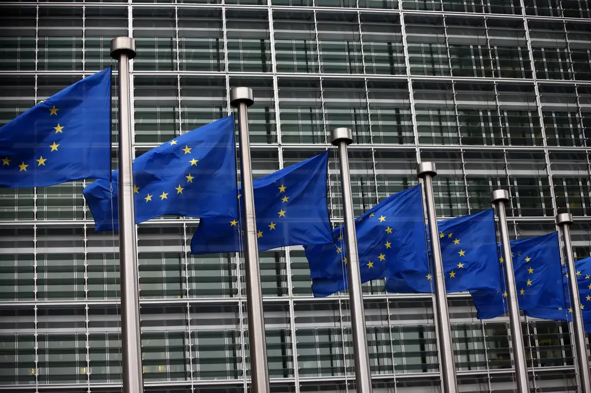 European Union flags outside a modern glass building